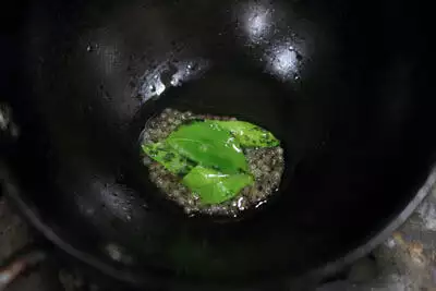 The tempering of mustard seeds and curry leaves.