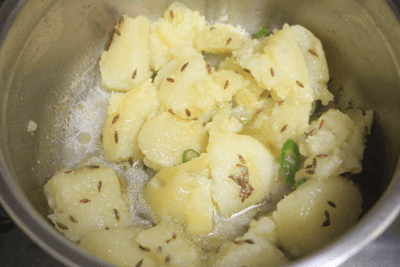 Water added to the pan with potatoes to cool it down a bit.