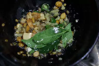 Tempering of udad dal, chana dal, cashew nuts, ginger, green chillies, and curry leaves.