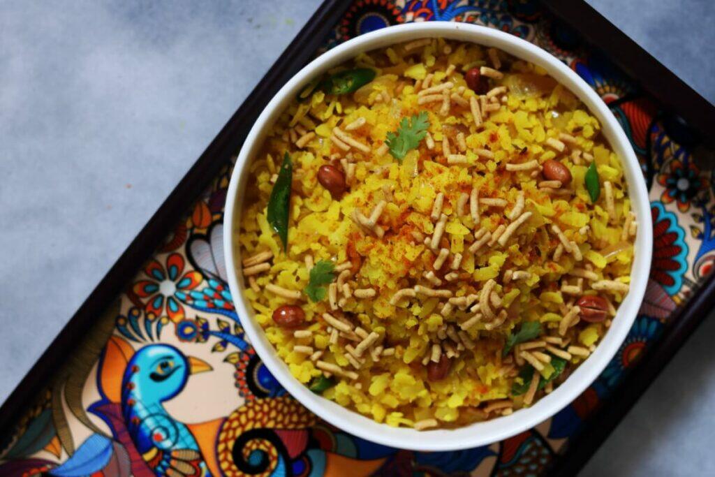 Indori Steamed Poha topped with Spicy Ratlami Sev, Cruncy Peanuts and Jeeravan Masala