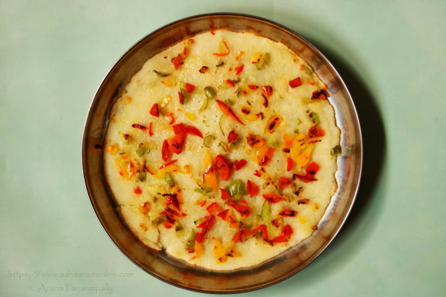 Rava Uttapam: Semolina Pancake topped with red, yellow, and green bell peppers. 