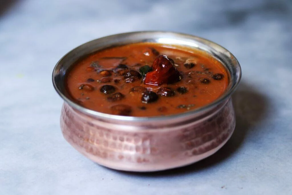 a bowl of Sundakkai Vatha Kuzhambu or Turkey Berry in a Spicy Tamarind Gravy