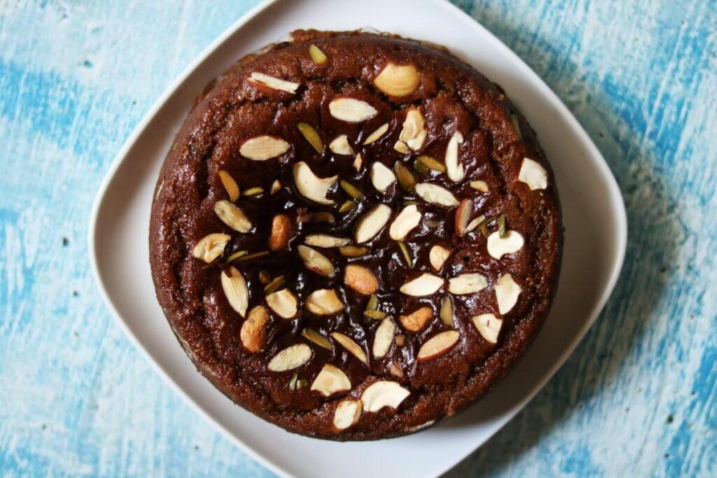 Eggless whole wheat jaggery cake topped with nuts