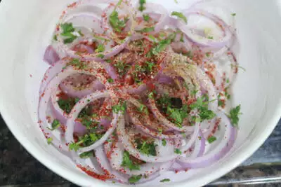 Onion rings to which spices and chopped coriander has been added