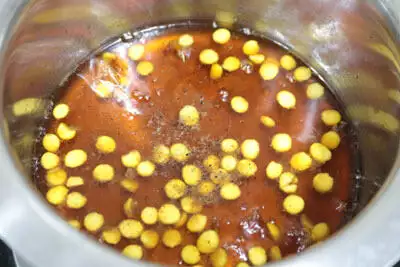 Ghee and cardamom powder added to the jaggery syrup.